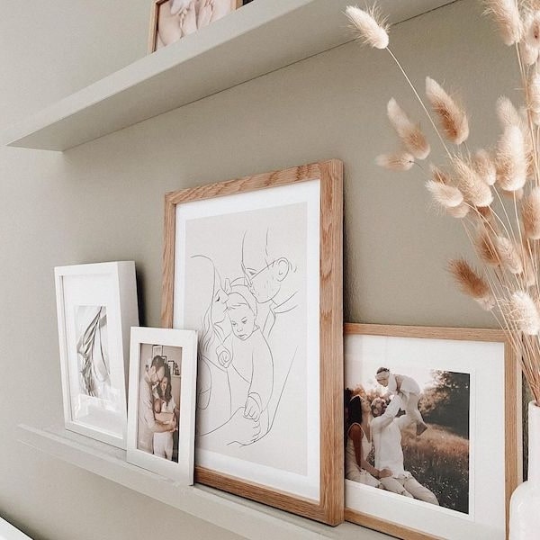 Bilderwand mit Familienbildern, dazwischen eine Line Art Zeichung einer jungen Familie, Instagram Post von @adriane